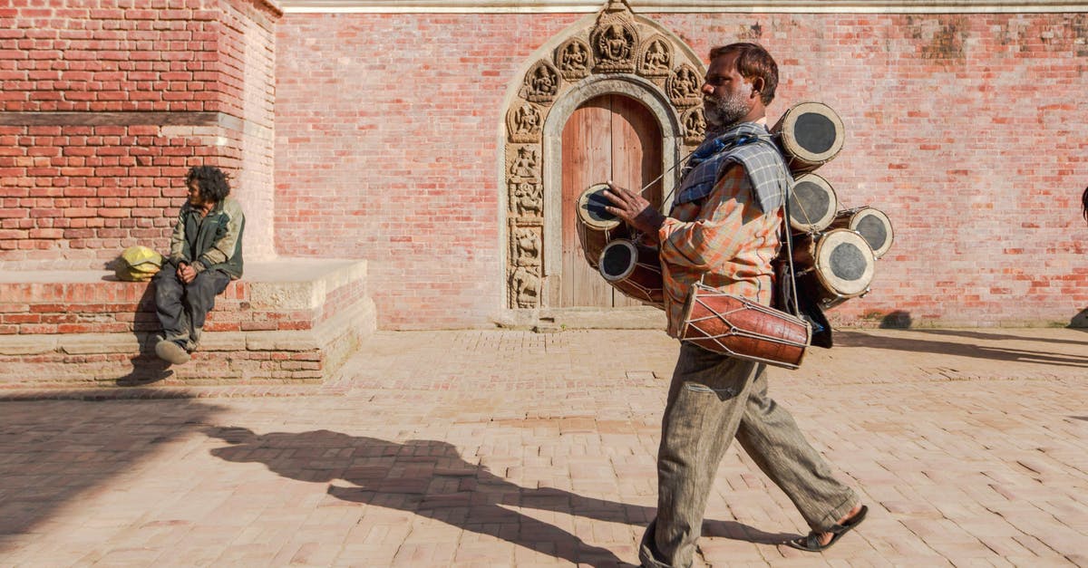 Why didn't Dr.strange use the time stone when this event occurred? [duplicate] - Full body of ethnic man carrying traditional musical instruments while walking on block stone pavement along street near brick building in bright sunlight