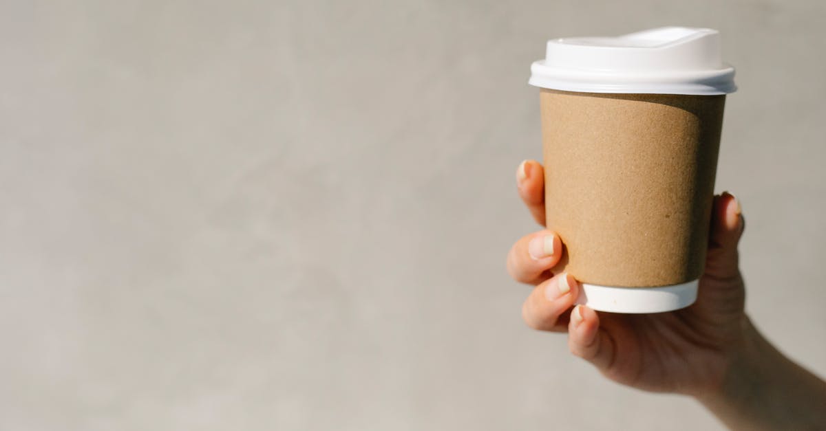 Why didn't Four warn the rest of Dauntless what was going to happen? - Anonymous woman demonstrating paper cup of takeaway coffee against gray background in sunny morning