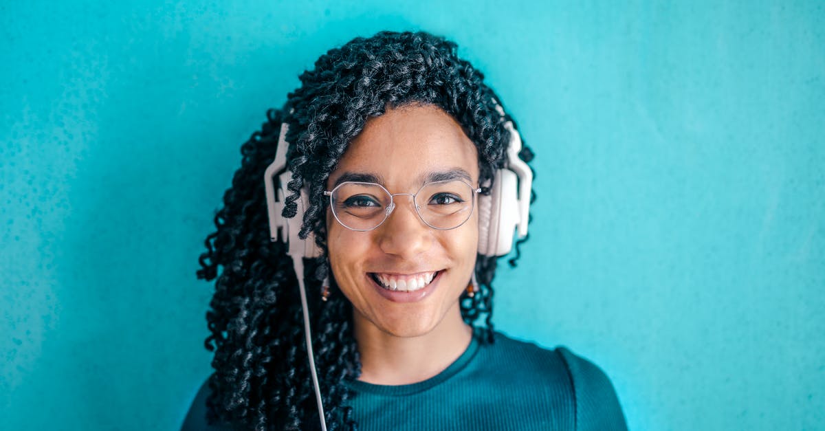 Why didn't George VI simply deliver his address while listening to music on headphones? - Portrait Photo of Smiling Woman in Black T-shirt ans Glasses Wearing White Headphones