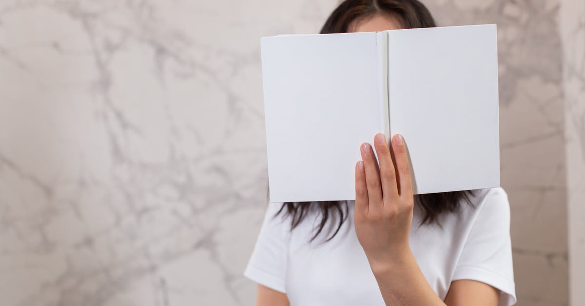Why didn't Hannah notice this? - Unrecognizable female in casual t shirt with opened white mock up notebook in hands standing in light room near wall