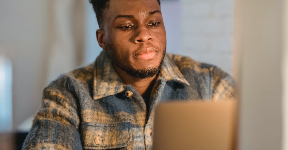 Why didn't the Avengers consider using Ant-Man this way? - Concentrated young bearded African American man in trendy shirt sitting in front of laptop and attentively looking at screen