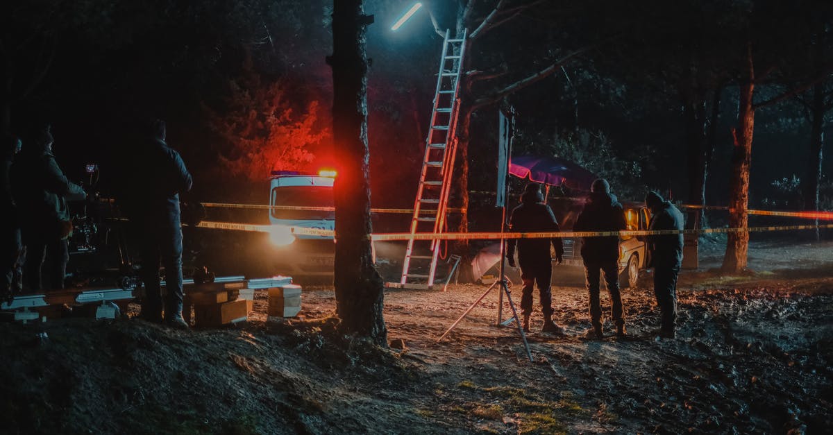 Why didn't Tobey tell the police that Julia could confirm Dino was with them before the illegal race? - Group of colleagues investigating crime scene fenced with tape among trees at dark night