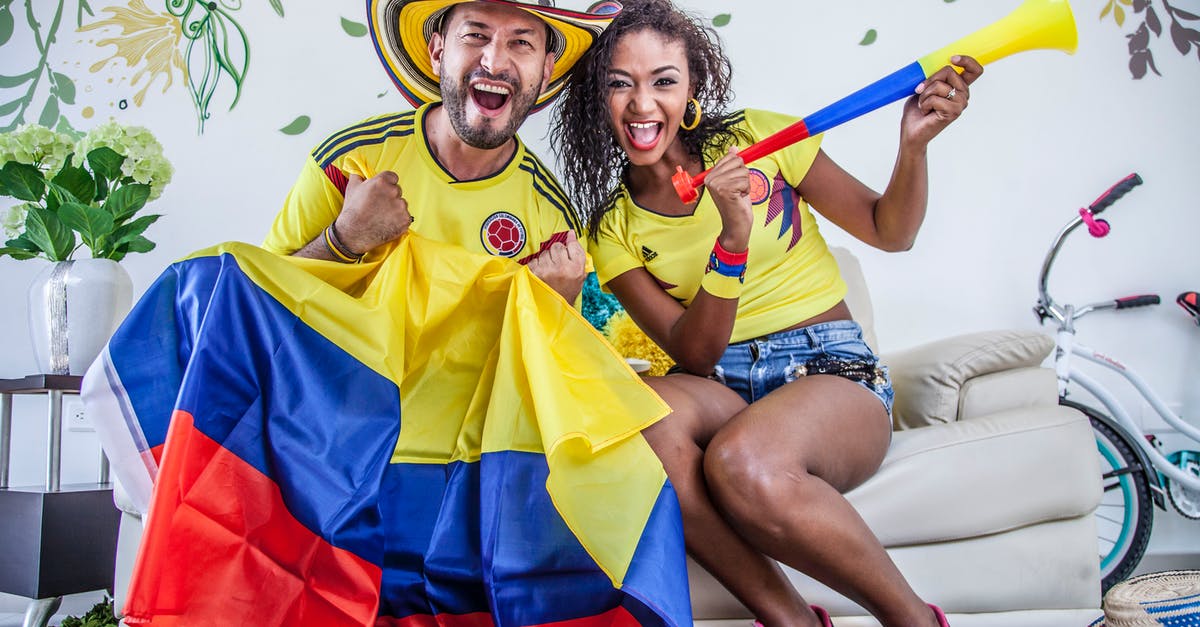 Why didn’t Beth return to see Mr. Shaibel after she gained national recognition? - Excited ethnic couple with Colombian flag and toy pipe