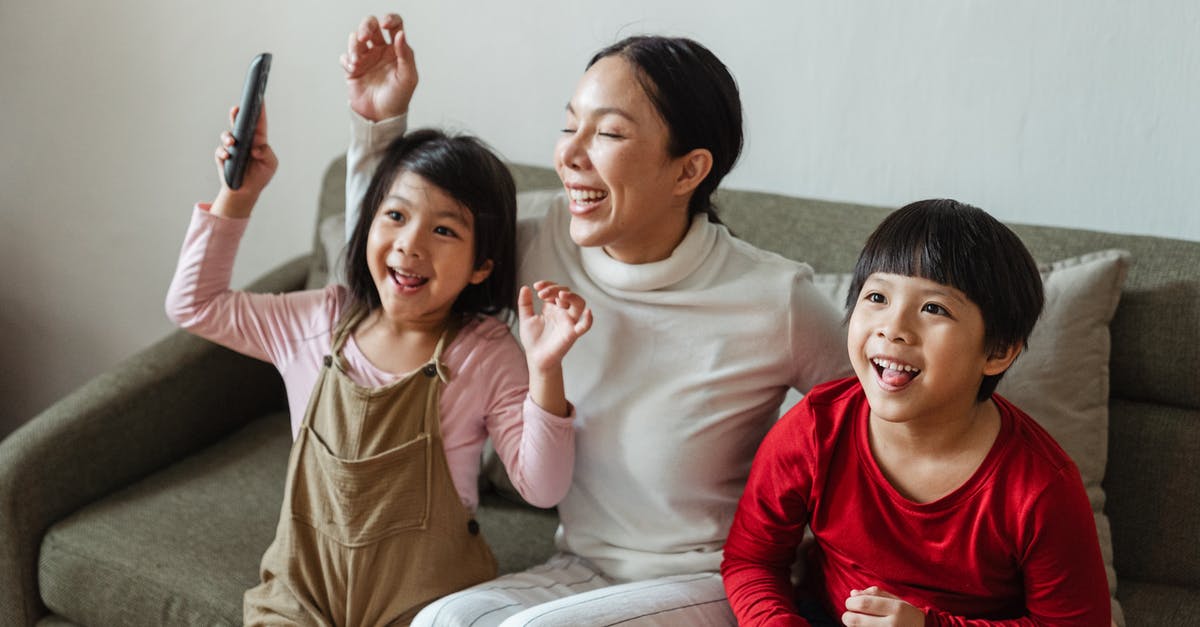 Why do cable and TV have watermarks on their programming? - Excited young ethnic woman with kids watching funny cartoon on TV