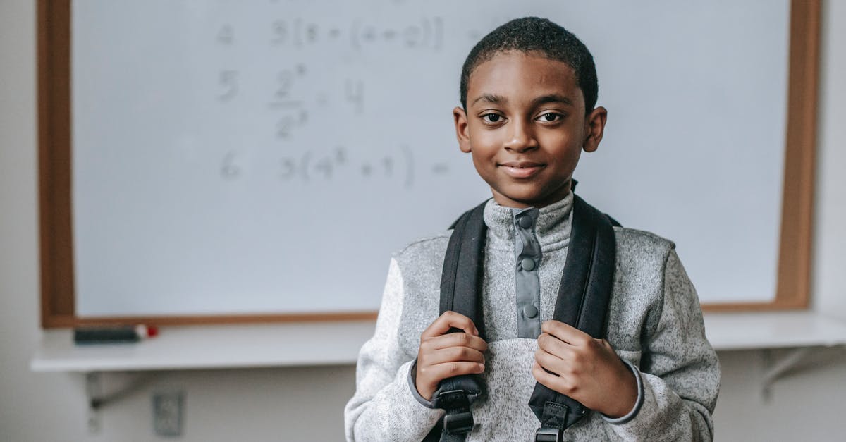 Why do detectives Regan and Baker wear the "08" precinct number if they're not from there? - Smiling black schoolboy near white board in classroom