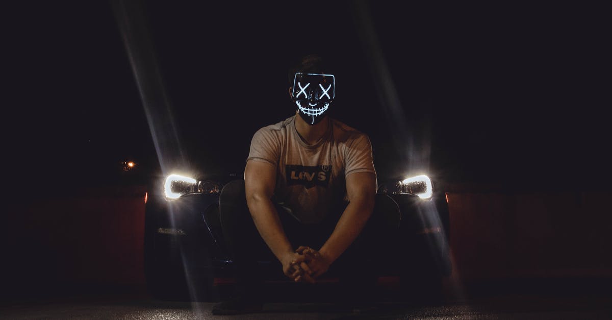 Why do people never turn off the car headlights when they stop the engine? - Photo of Man Wearing Mask in Front of Car