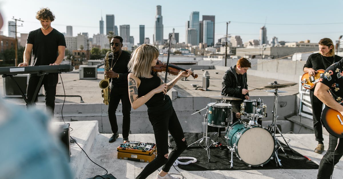 Why do prisoners want to live in Emerald City? - Woman Playing Violin on the Rooftop with Music Band