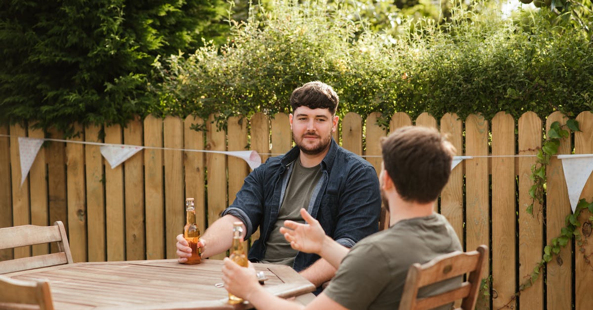 Why do "dead men tell no tales"? - Male friends drinking beer at table in backyard