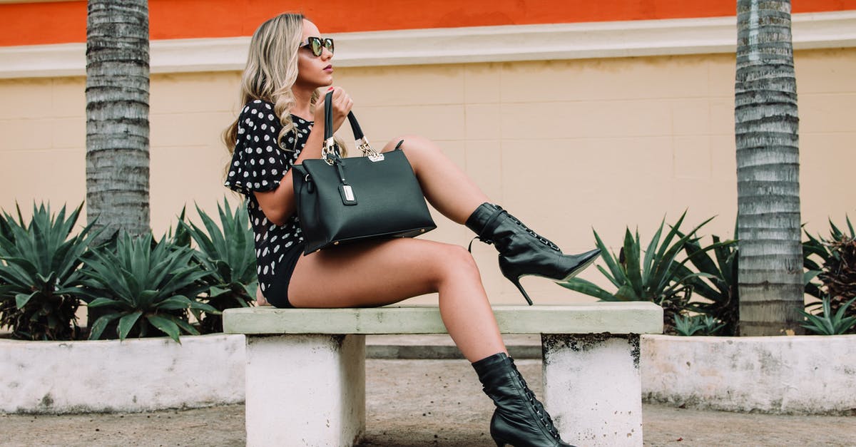 Why do the handmaids wear those boots? - Woman Wearing Black and White Polka-dot Shirt With Black Short Shorts Holding Black Leather Tote Bag Sitting on White Concrete Bench