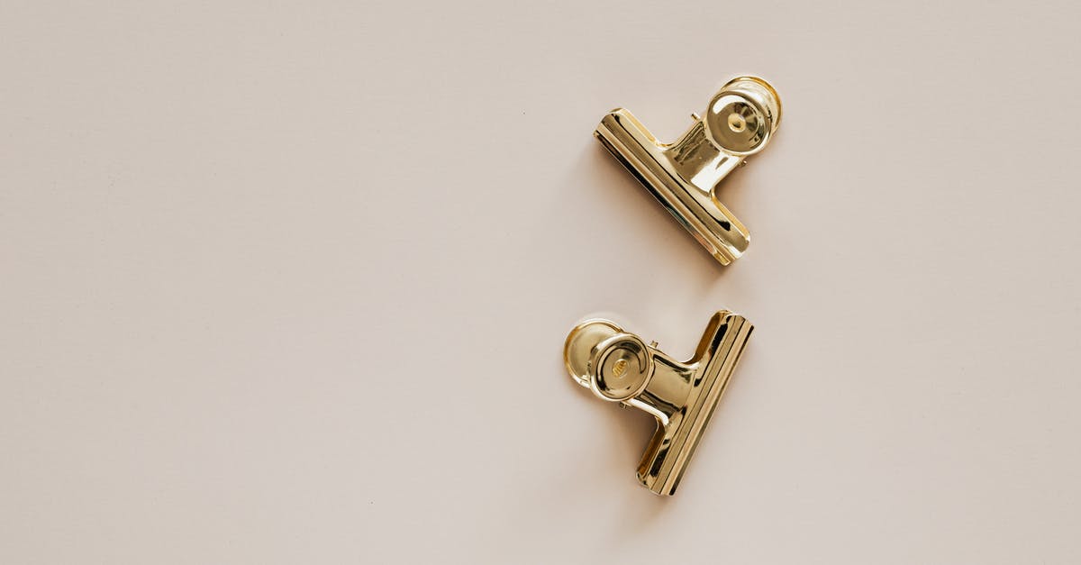 Why do the horsemen bother passing the item from one to another while being searched? - Golden metal clips on beige background