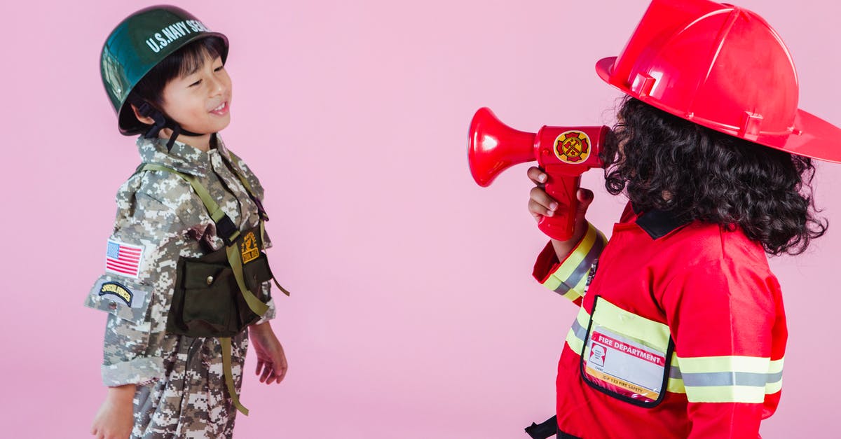 Why do these Japanese Navy officers have a US Navy flag patched on their uniform? - Side view of multiethnic kids wearing navy uniform and firefighter costume with loudspeaker standing together on pink background in hardhats and looking at each other