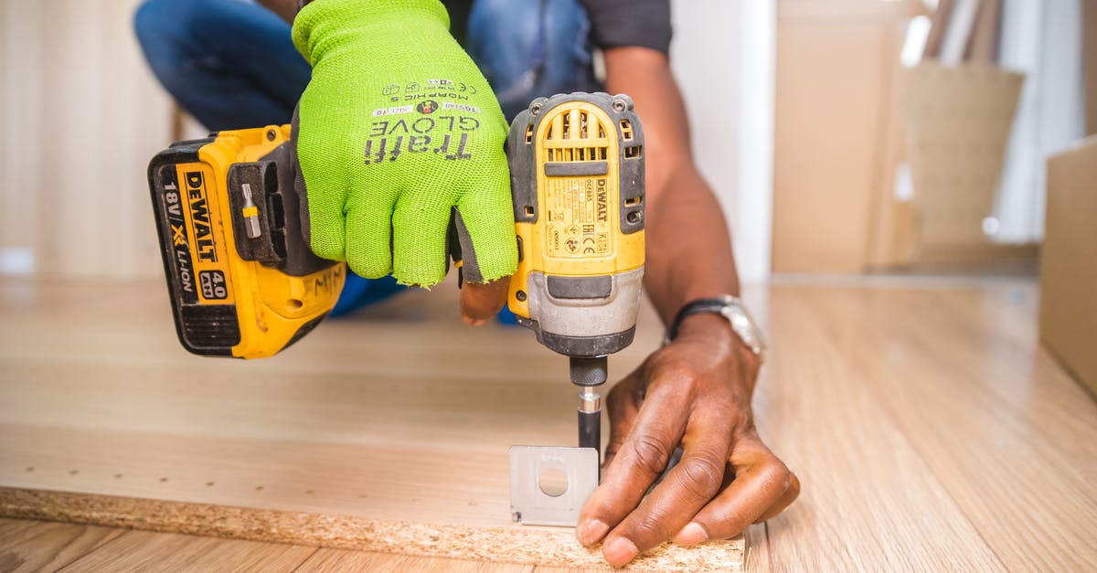 Why do they never wear gloves? - Person Using Dewalt Cordless Impact Driver on Brown Board