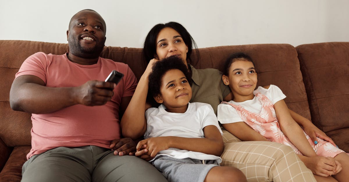 Why do TV series and films get removed from Netflix Streaming? - Family Sitting on a Brown Couch Watching TV