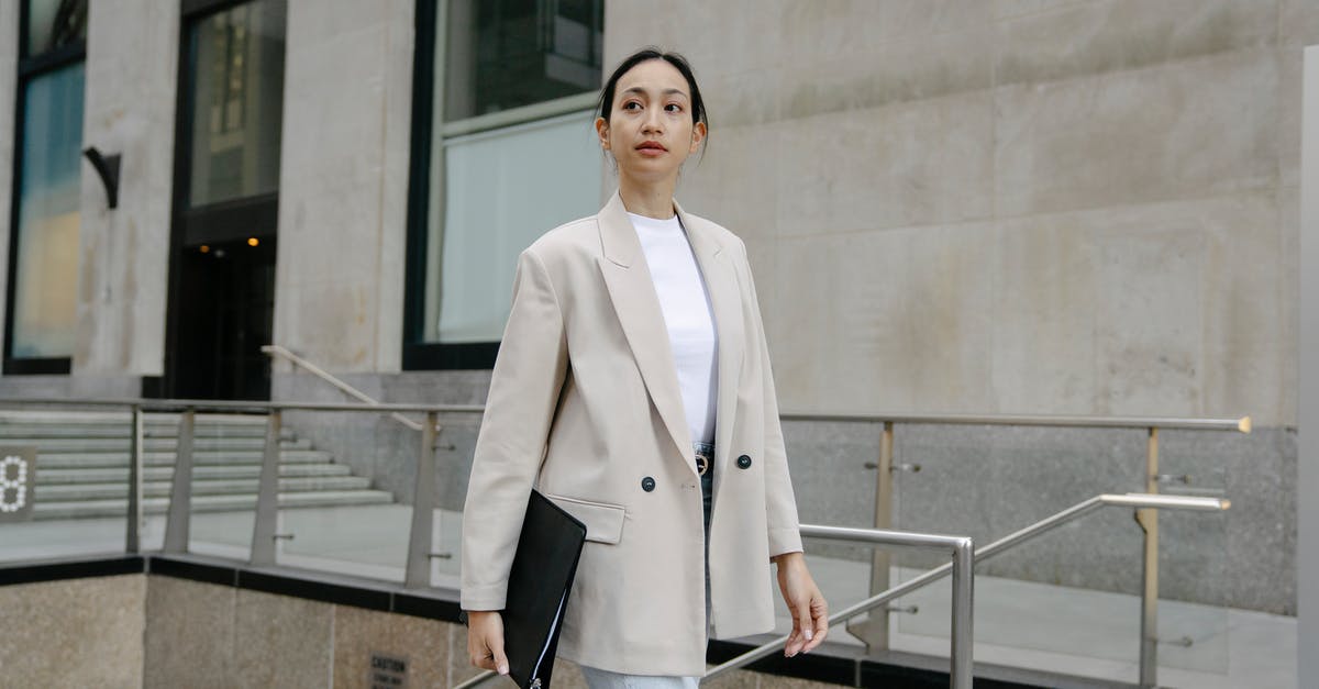 Why does Anzor walk away? - Confident Asian female entrepreneur in stylish outfit and with folder walking in city street and looking away