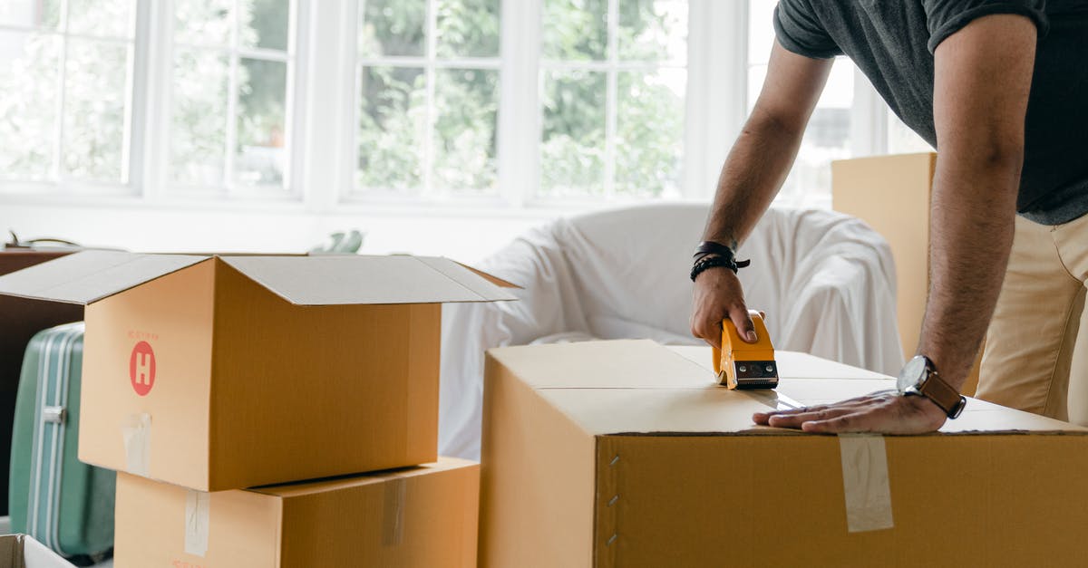 Why does Borden want to change the knot used in the trick? - Crop unrecognizable man in casual clothes packing carton box using scotch tape dispenser for moving personal items to new apartment