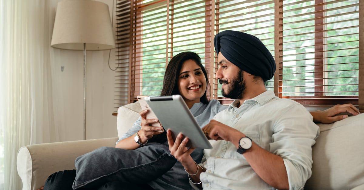 Why does Brody's wife call him by his surname? - Indian couple with tablet and smartphone on couch at home