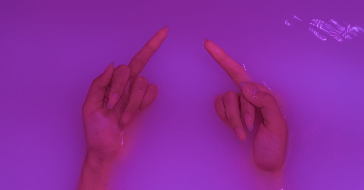Why does Dr. Cox from Scrubs hate Hugh Jackman? - Top view of crop anonymous rude female demonstrating middle fingers in aqua with neon light