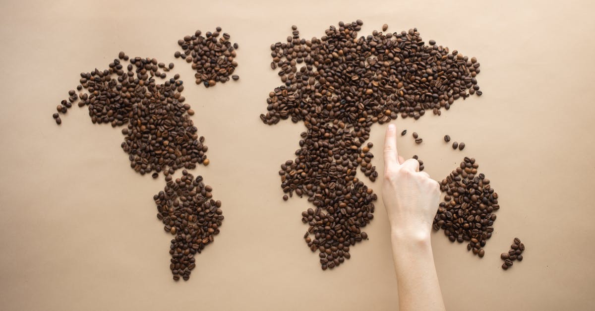 Why does Dr. Isaac point his finger to the bible in the meeting? - Top view of crop person pointing finger at world map made of coffee beans on brown background
