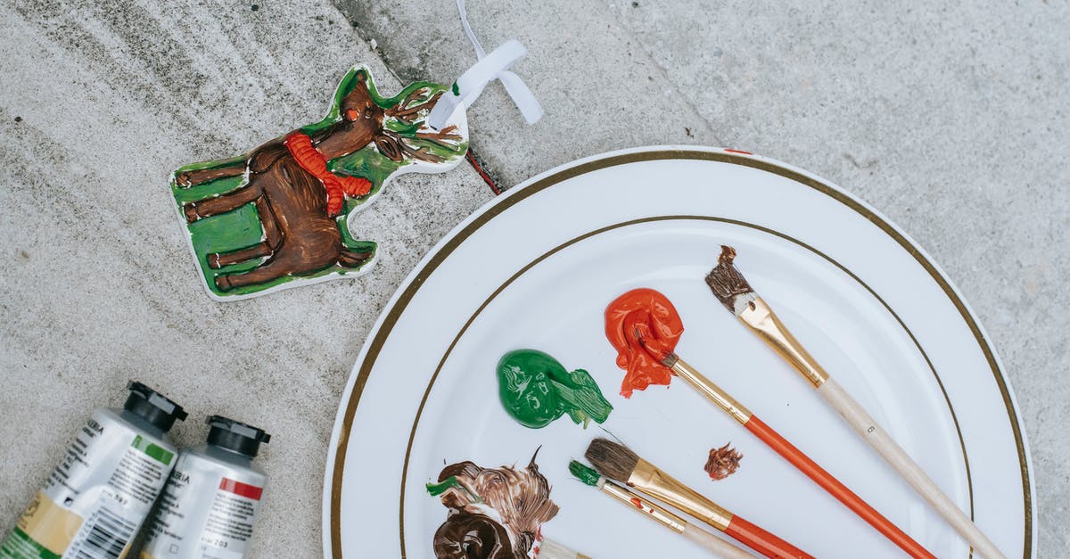 Why does Harrison show different reactions to phaser fire? - Flat lay of Christmas deer near tubes placed near plate with brushes and mixture of colorful paints