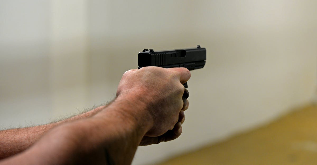 Why does Josh have a gun range target in his office? - Crop man firing pistol in shooting range