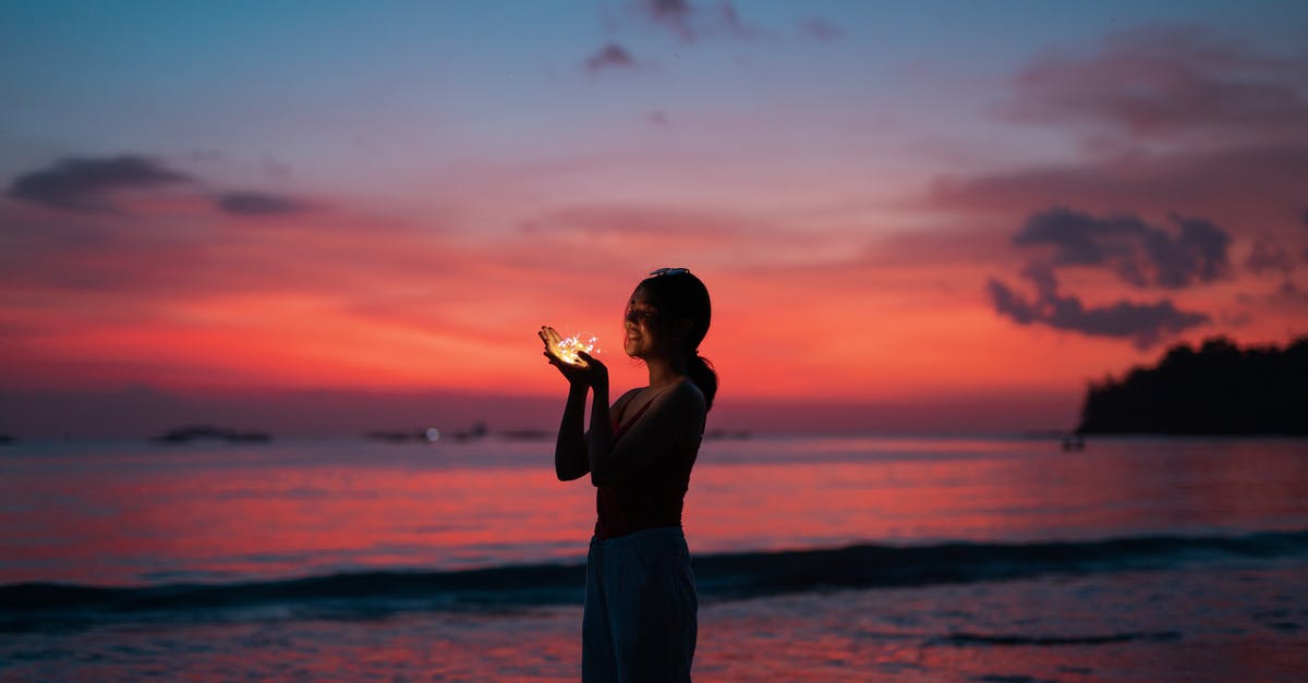 Why does Joy glow? - Woman holding lights on seashore at sunset