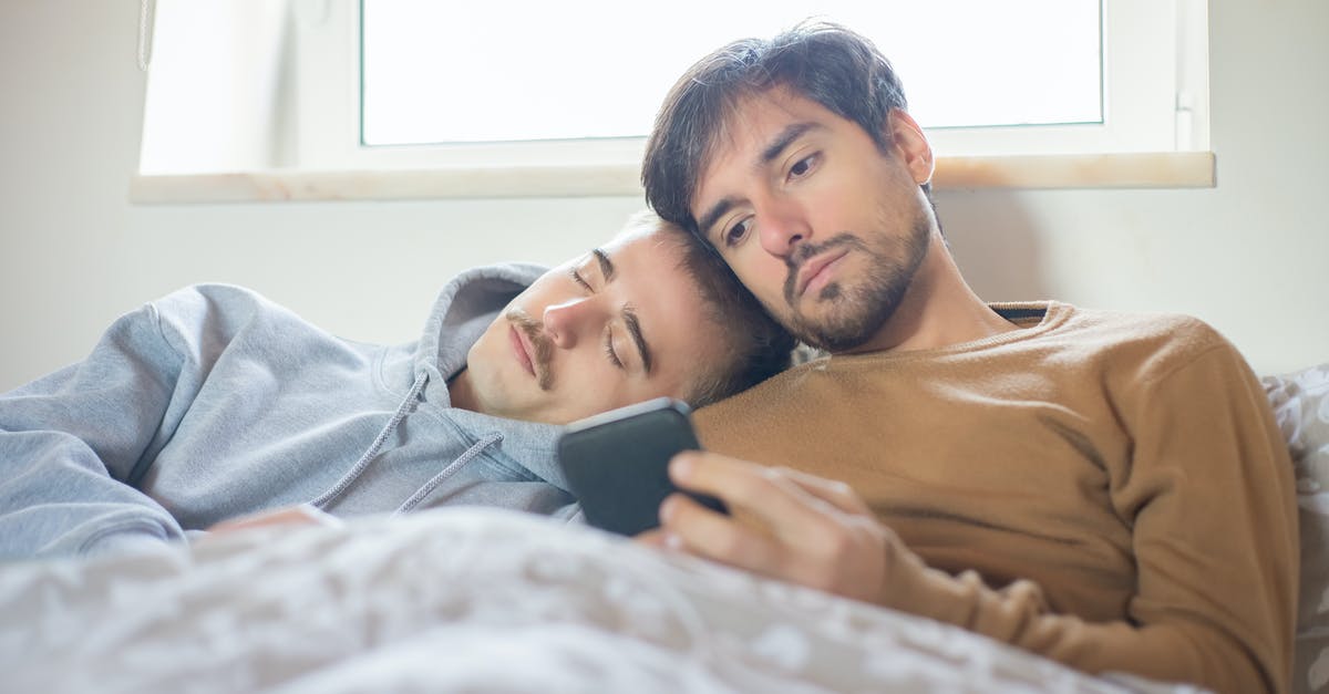 Why does Jules use gay men to "conquer femininity"? - Photo of a Man in a Brown Shirt Using His Phone Beside a Man in a Gray Hoodie