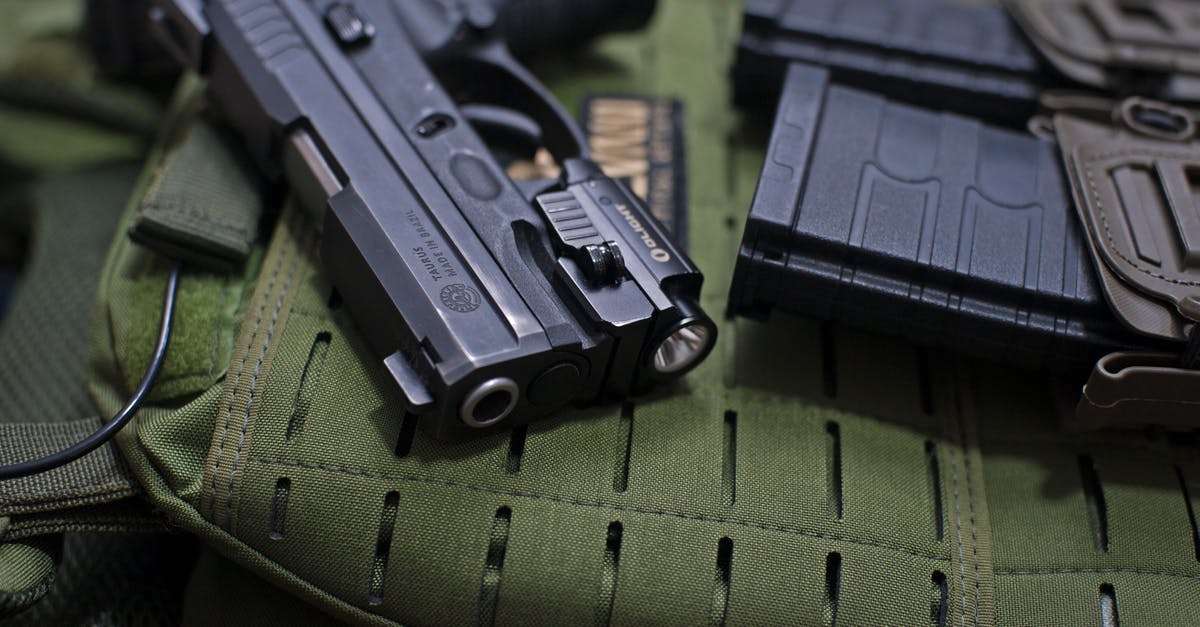 Why does K grab a gun before the past is changed? - Black Semi Automatic Pistol on Green Textile