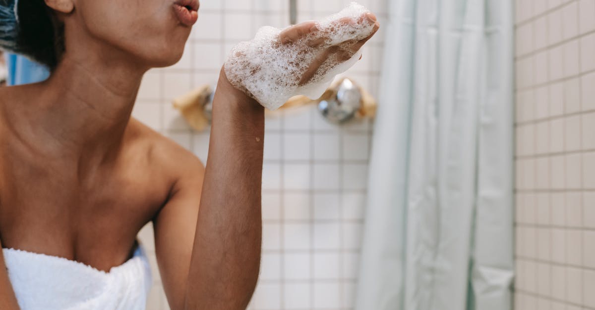 Why does Lily remove her panties in Black Swan? - Side view of crop anonymous African American female in towel blowing off foam from hand in bathroom