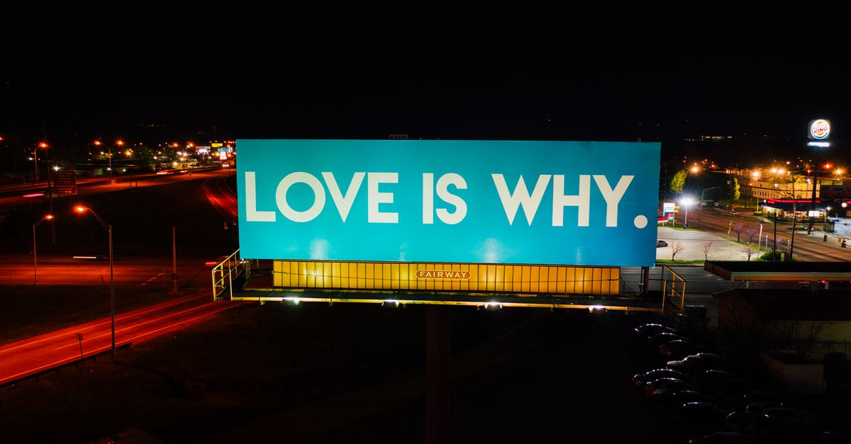 Why does Marianne attend public school? - Blue billboard saying Love is why placed on road surrounded by cars and street lights against black night
