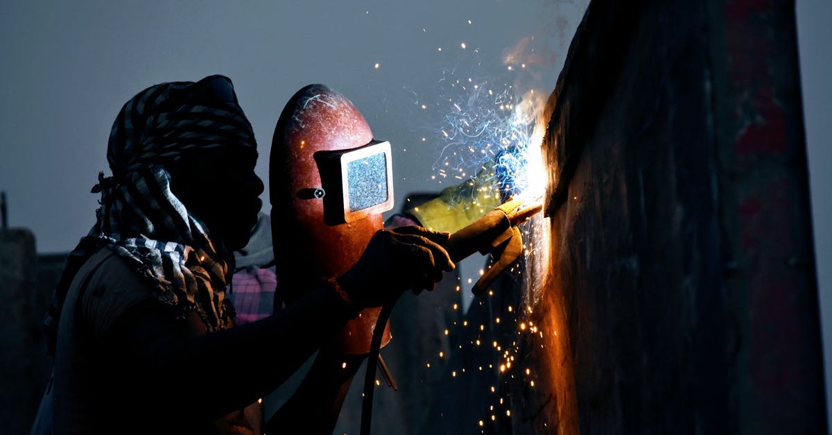 Why does Masters torch his paintings? - Anonymous black male welder working with torch on street