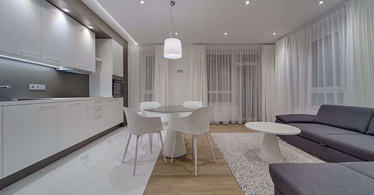 Why does Mr. Hinx go to Mr. White's house even when Spectre already knew he is dead? - Minimalist modern design of kitchen with white cabinets and gray sofa in contemporary illumination