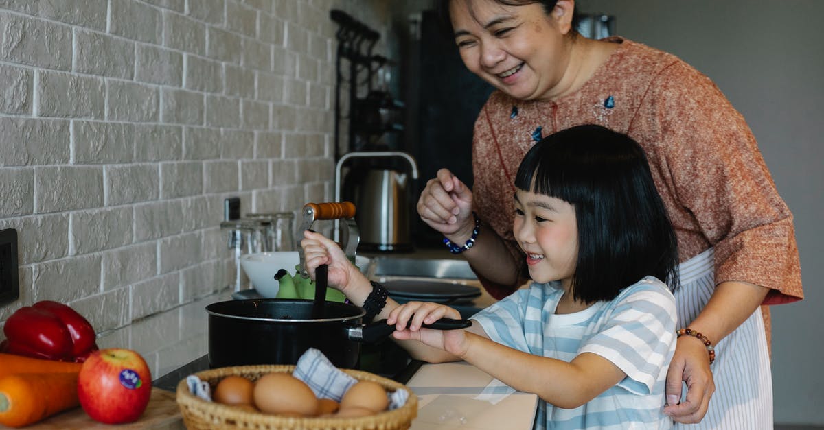 Why does Peter Pan age in Hook? - Asian woman with granddaughter preparing food
