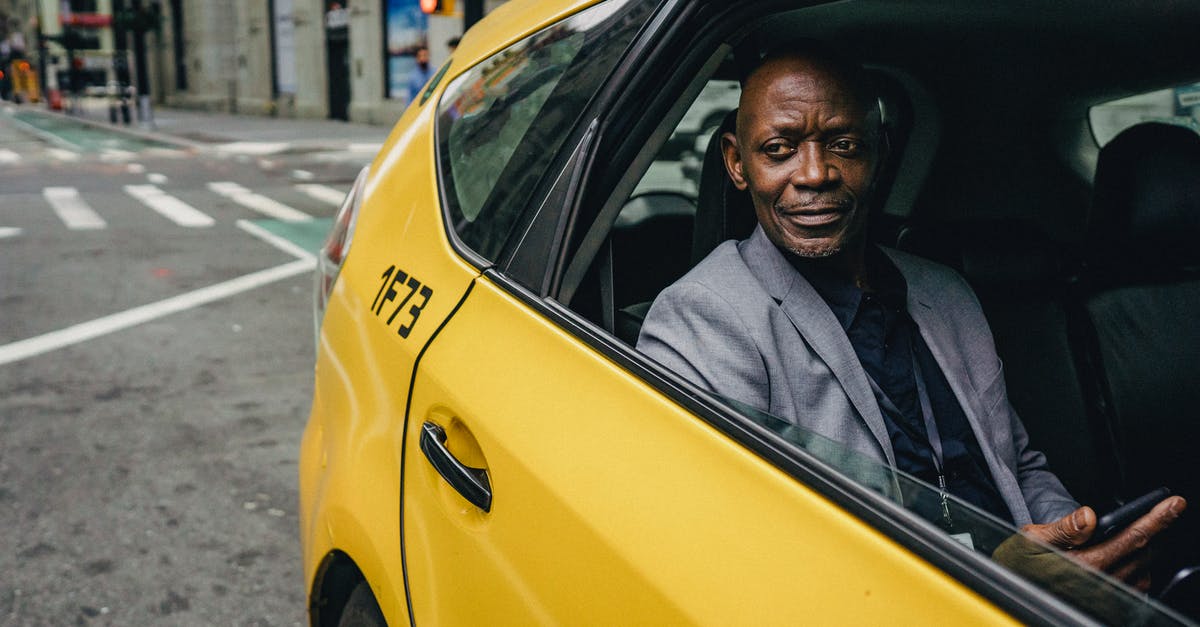 Why does Robert Angier not use a double for "The Real Transported Man"? - Happy confident mature African American male looking away and expecting important message on mobile phone while sitting in yellow automobile