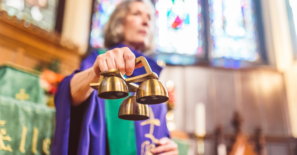 Why does Schofield hear church bells when the church is on fire? - Woman Priest Holding Altar Bells 