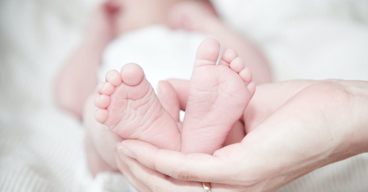 Why does she give birth to a dog-headed baby? - Close-up of Hands Holding Baby Feet
