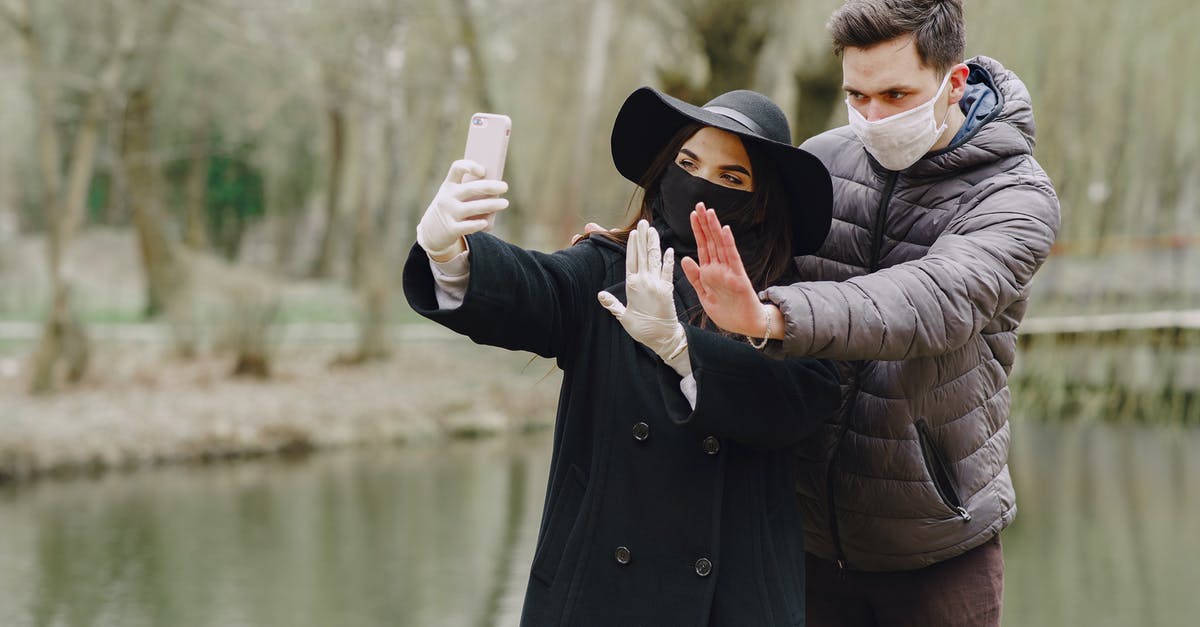 Why does Steve decide against using the Rohypnol? - Serious couple in outwear wearing surgical gloves and masks taking selfie on smartphone and showing stop gesture while standing near lake in spring park during coronavirus pandemic