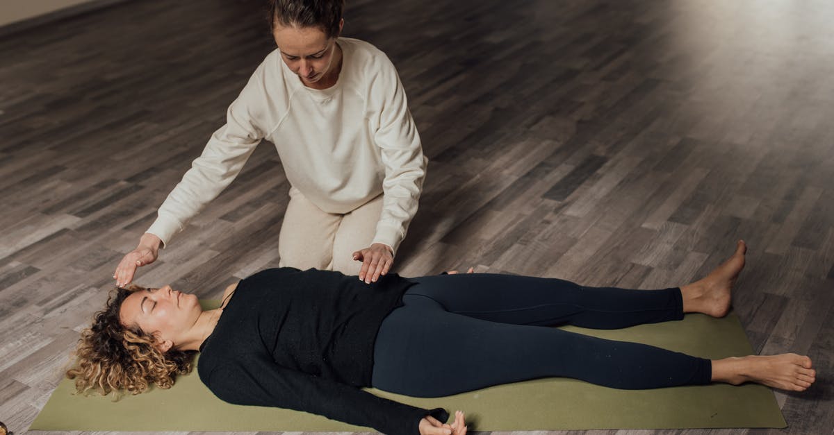 Why does the eye surgeon help Anderton - Energy practitioner healing relaxed woman on yoga mat