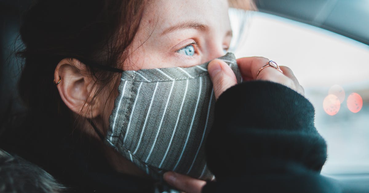 Why does the First Doctor wear a ring on his small finger? - Woman putting on protective mask in car