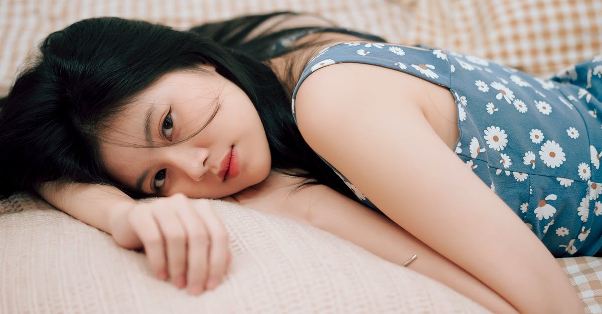 Why does the human blood look colorless in this scene? - Woman in Blue and White Floral Shirt Lying on Bed