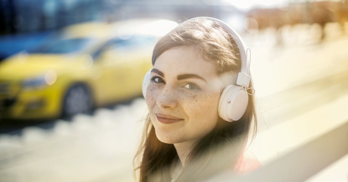 Why does the song 'Car Wash' appear so often in Eureka? - Happy young woman in headphones listening to music on street