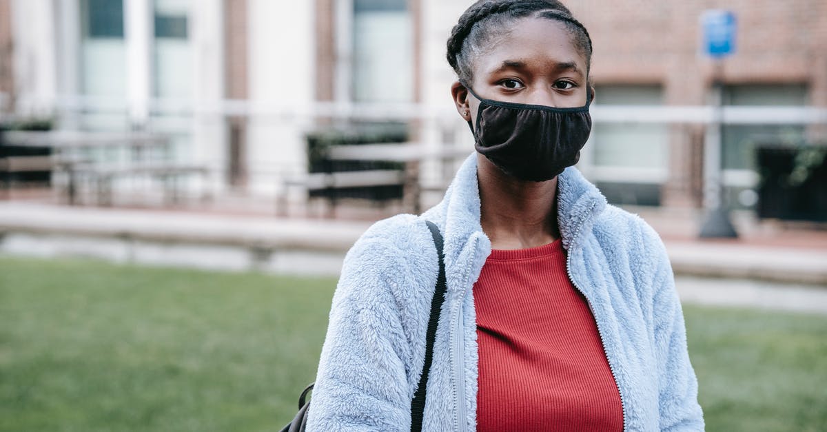Why does Tommy wear a hockey mask in the end of Friday the 13th: A New Beginning? - Anonymous young African American female in face mask looking at camera in town during coronavirus pandemic
