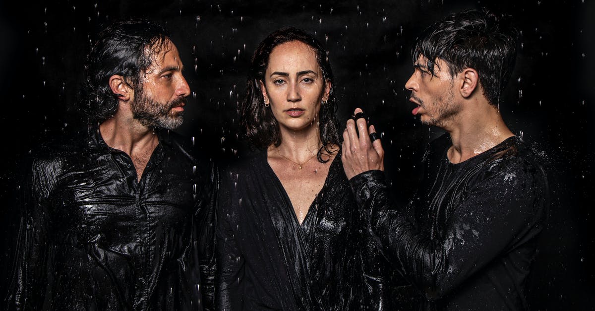 Why does William Crandall perform such an unexpected act? - Photogenic talented artists wearing wet black clothes standing in studio under water drops