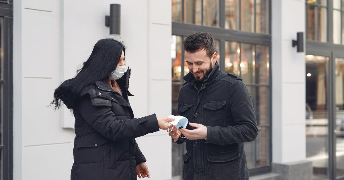 Why doesn't Agent 33 take off her mask in Agents of S.H.I.E.L.D. season 2? - Cheerful bearded man taking protective facial mask from girlfriend while standing together against city building facade during coronavirus pandemic at daytime