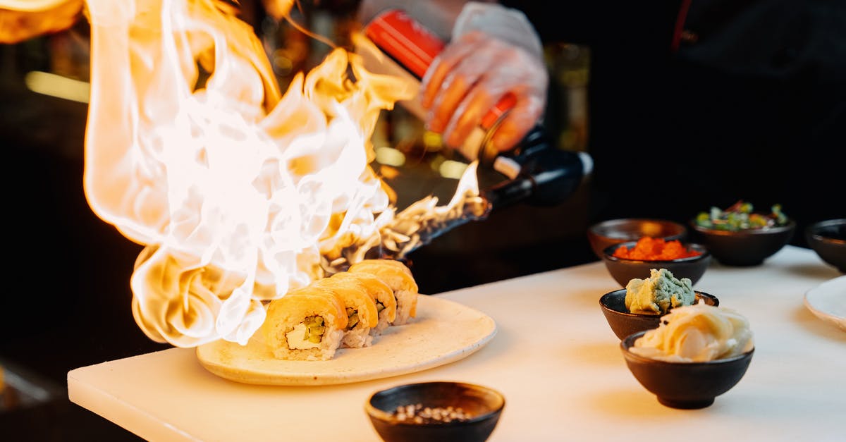 Why doesn't Bane immediately blow up Gotham when he sees the Bat-symbol on fire on the Gotham bridge? - A Chef Using a Blow Torch on Sushi Rolls