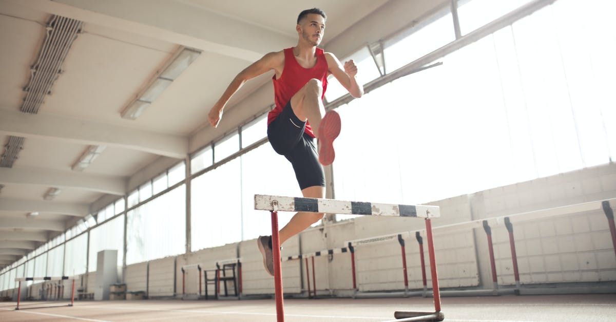 Why doesn't Bruce take a running jump when trying to escape from the pit? - Powerful male athlete jumping over hurdle on running track while training at sports hall