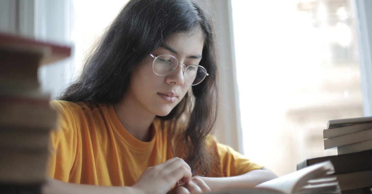 Why doesn't Cecilia think the police will be suspicious? - Low angle of diligent ethnic female student wearing casual t shirt and eyeglasses sitting at table with stacks of books and preparing for exam