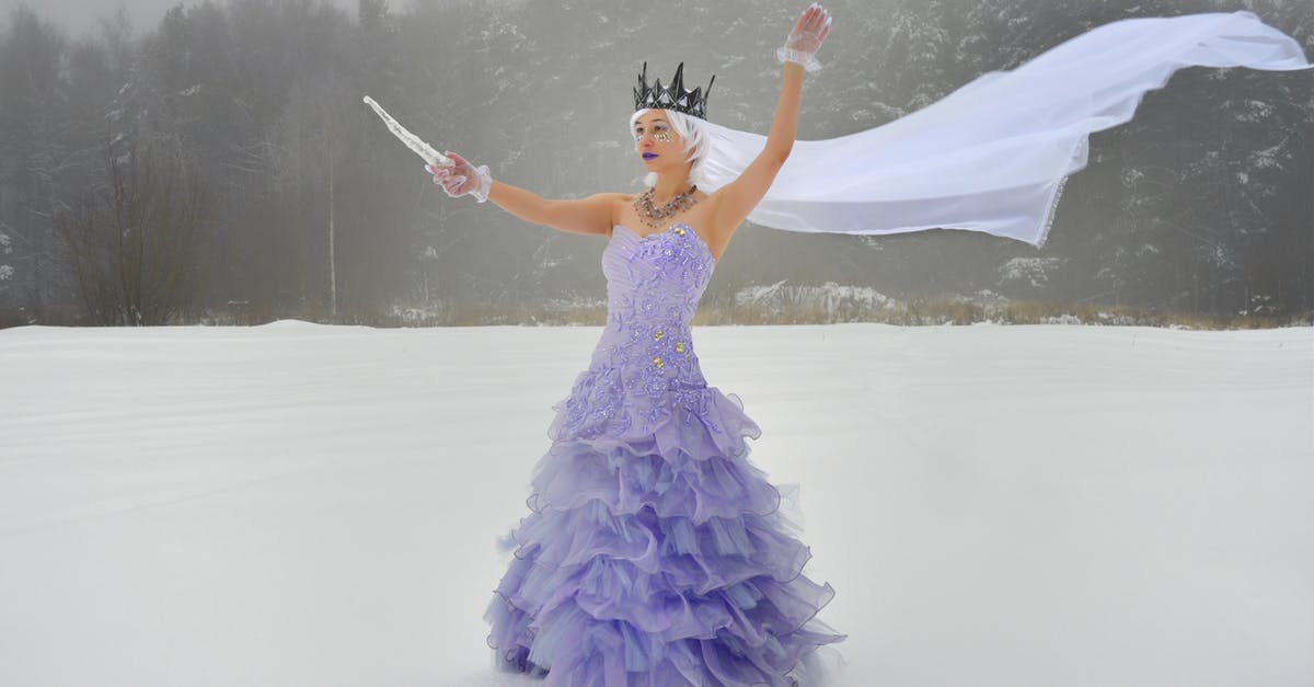 Why doesn't the Ice King's crown affect Jake? - Full body of young graceful female wearing crown and purple dress with icicle in hand and white veil while standing on snowy field near forest in winter day