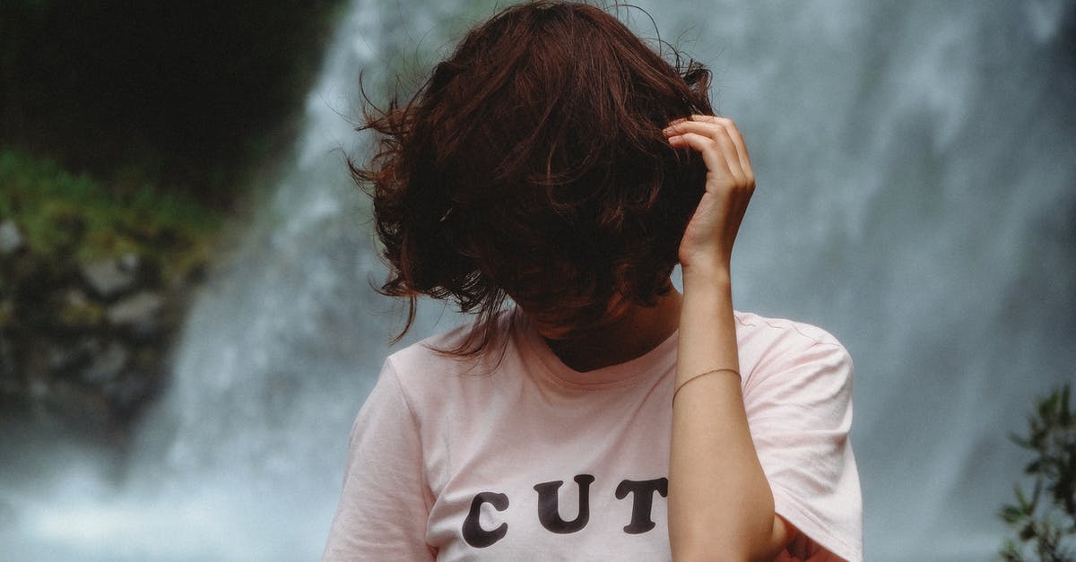 Why don't they cover themselves in zombie guts more often? - Woman Standing Looking Down While Holding Hair Near Waterfall