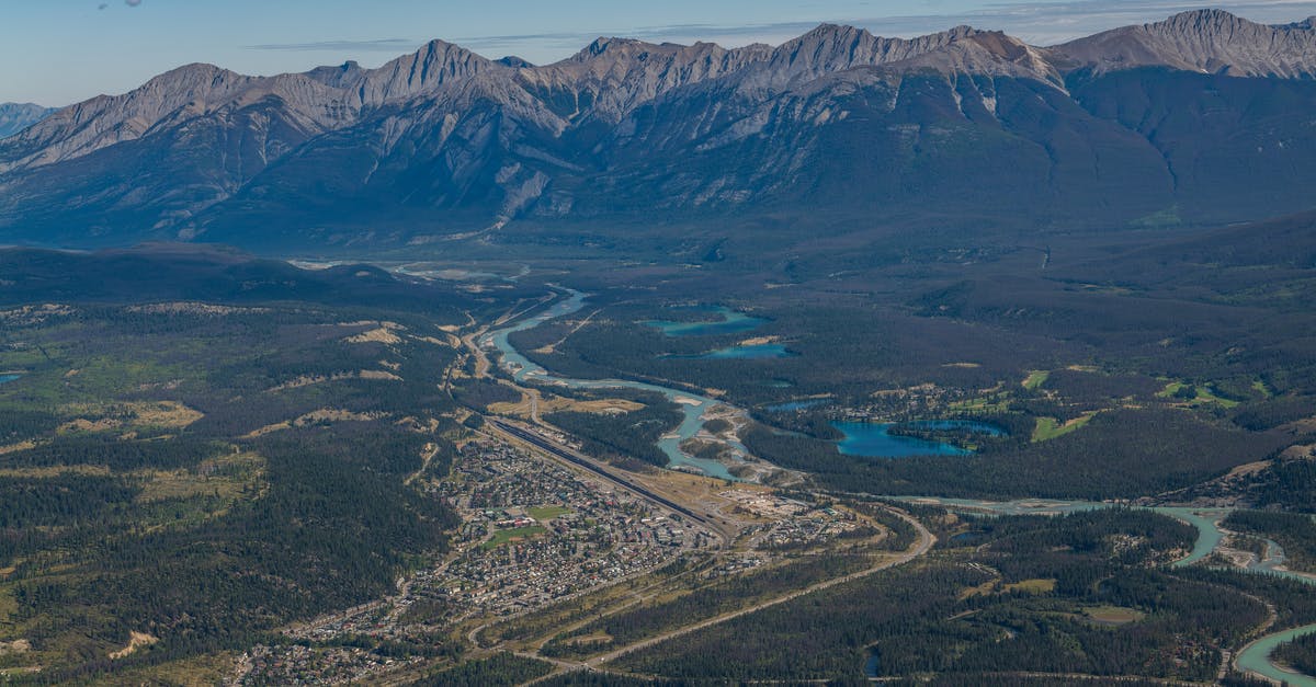 Why film in Canada when there's plenty of land in Montana? - Aerial Photography of a Town Near Water and Mountains