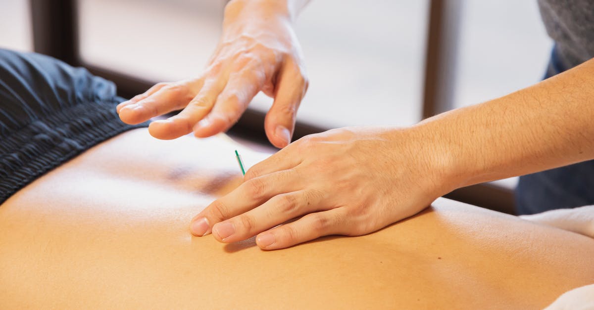 Why is a lottery conducted for sick patients to be cured? - Crop anonymous male doctor putting needles on back during acupuncture therapy session in rehabilitation salon